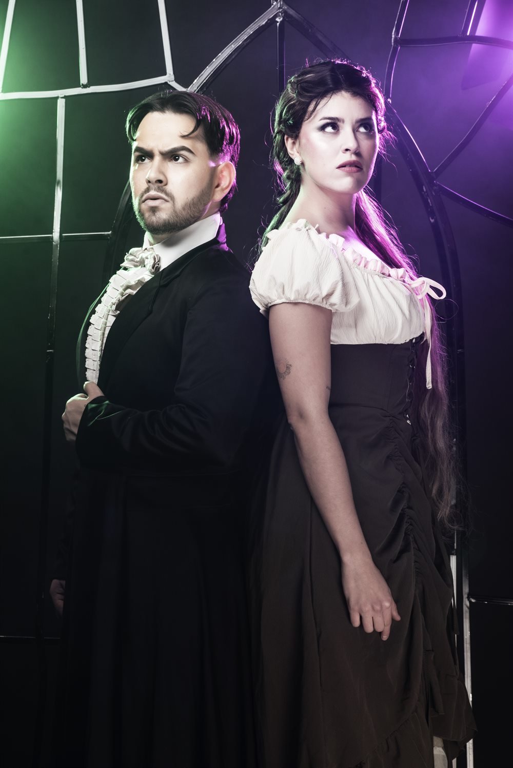 Dos personajes de Viva las Brujas bajo luces verdes y violetas